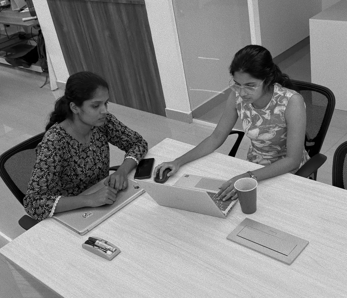 Two members of the Matsio team reviewing work together at a desk